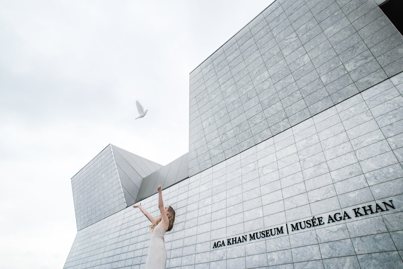 A bride releasing a white dove outside the Aga Khan Museum